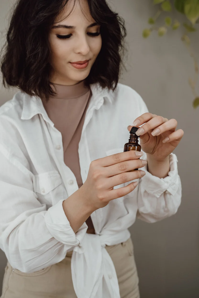 Young Woman Holding a Bottle of Essential Oil